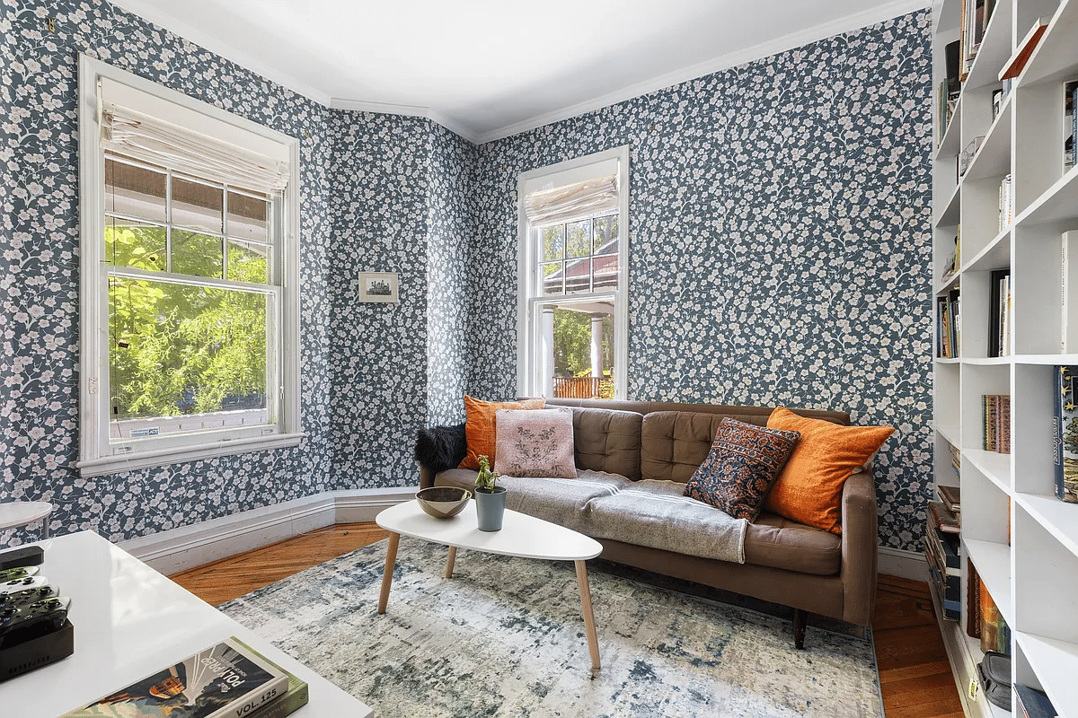 Library with blue floral wallpaper, wooden floor