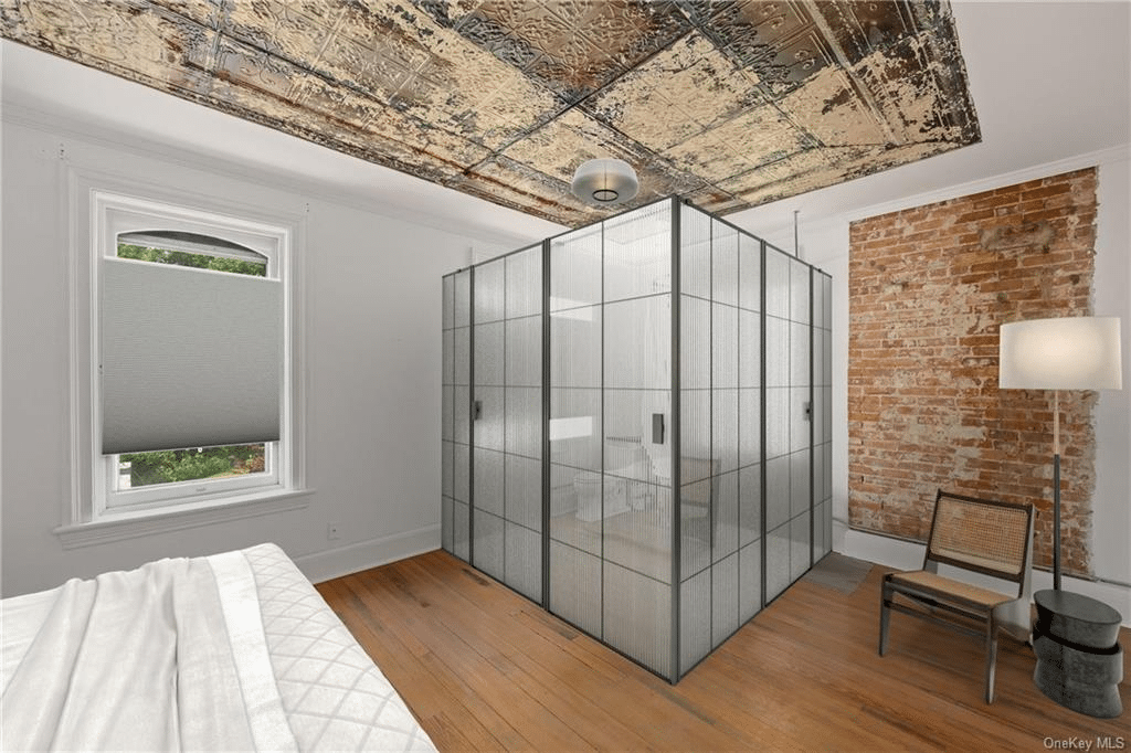 bedroom with glass box around bath