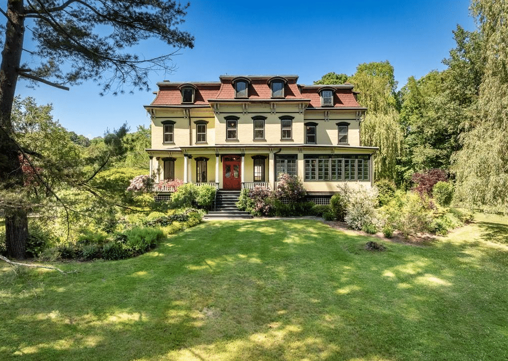 kingston - second empire house painted yellow surrounded by a lawn