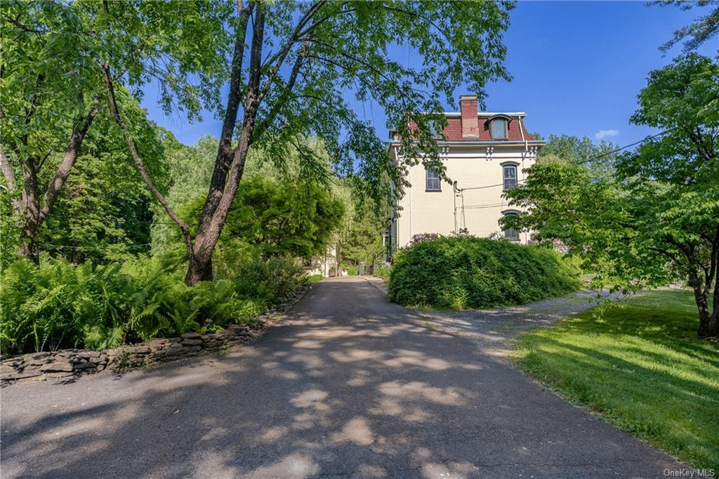 drive with view of mansard roof house