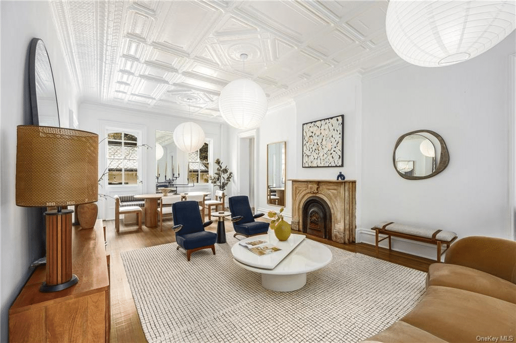 parlor with mantel, tin ceiling, wood floor