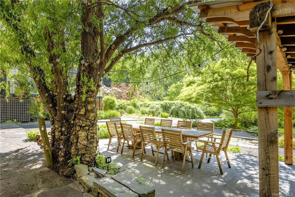 paved patio shaded by a large tree