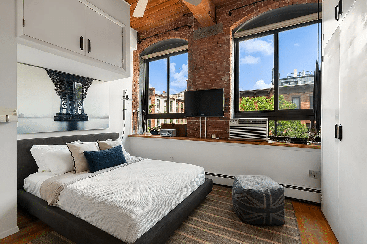 Bedroom with exposed beams and bricks