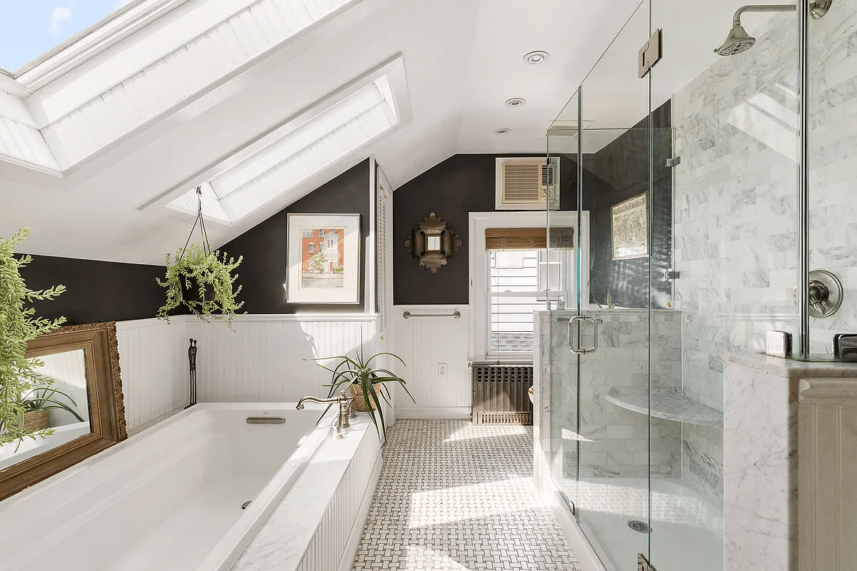 bathroom with skylights, glass shower, soaking tub