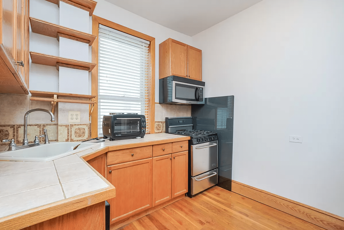 kitchen with wood cabinets, window, wood floor