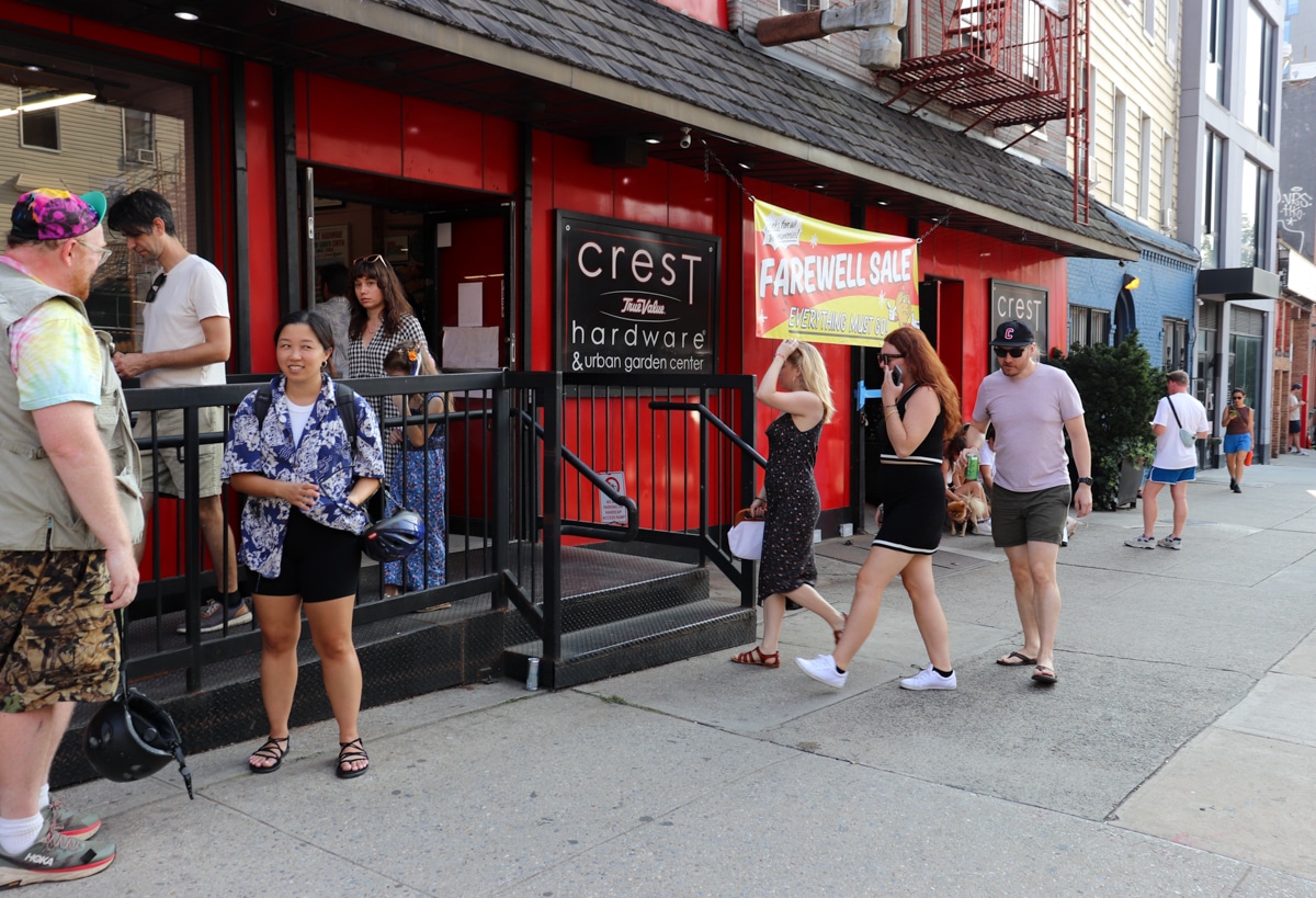 crest hardware - people outside the red storefront