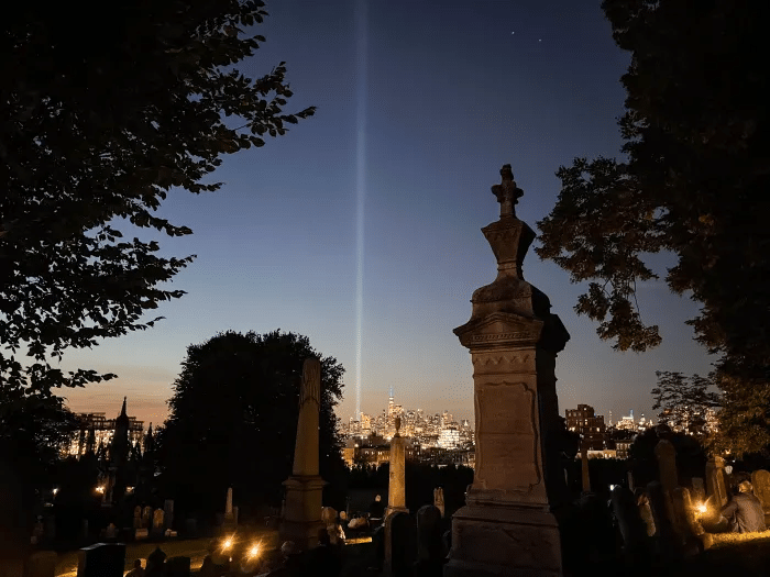 blue light marking the twin towers visible from green-wood cemetery