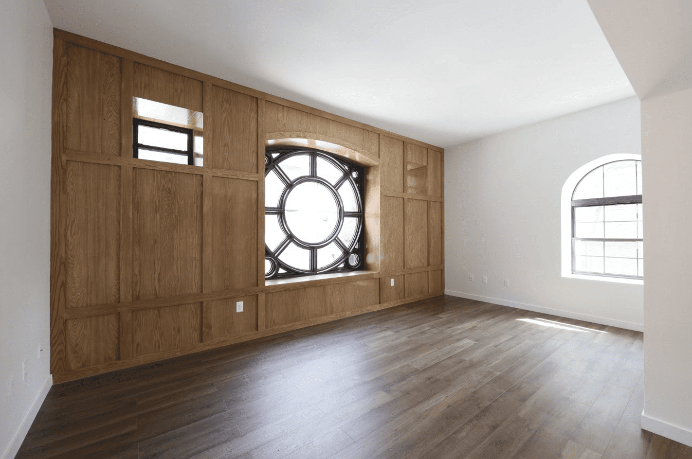 living room with wall of wood and circular window