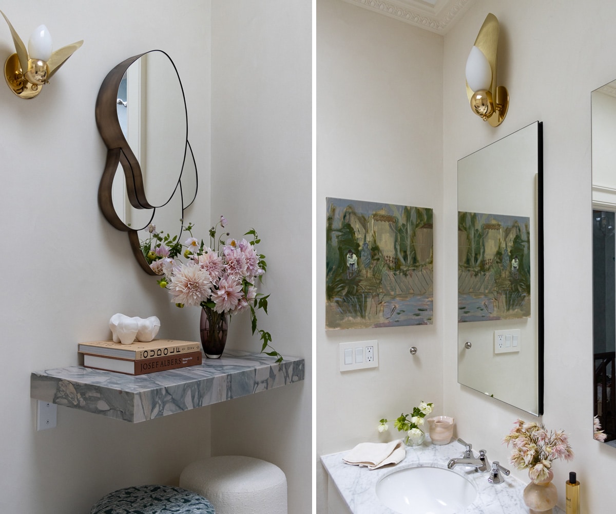 powder room with gold sconces and marble counters