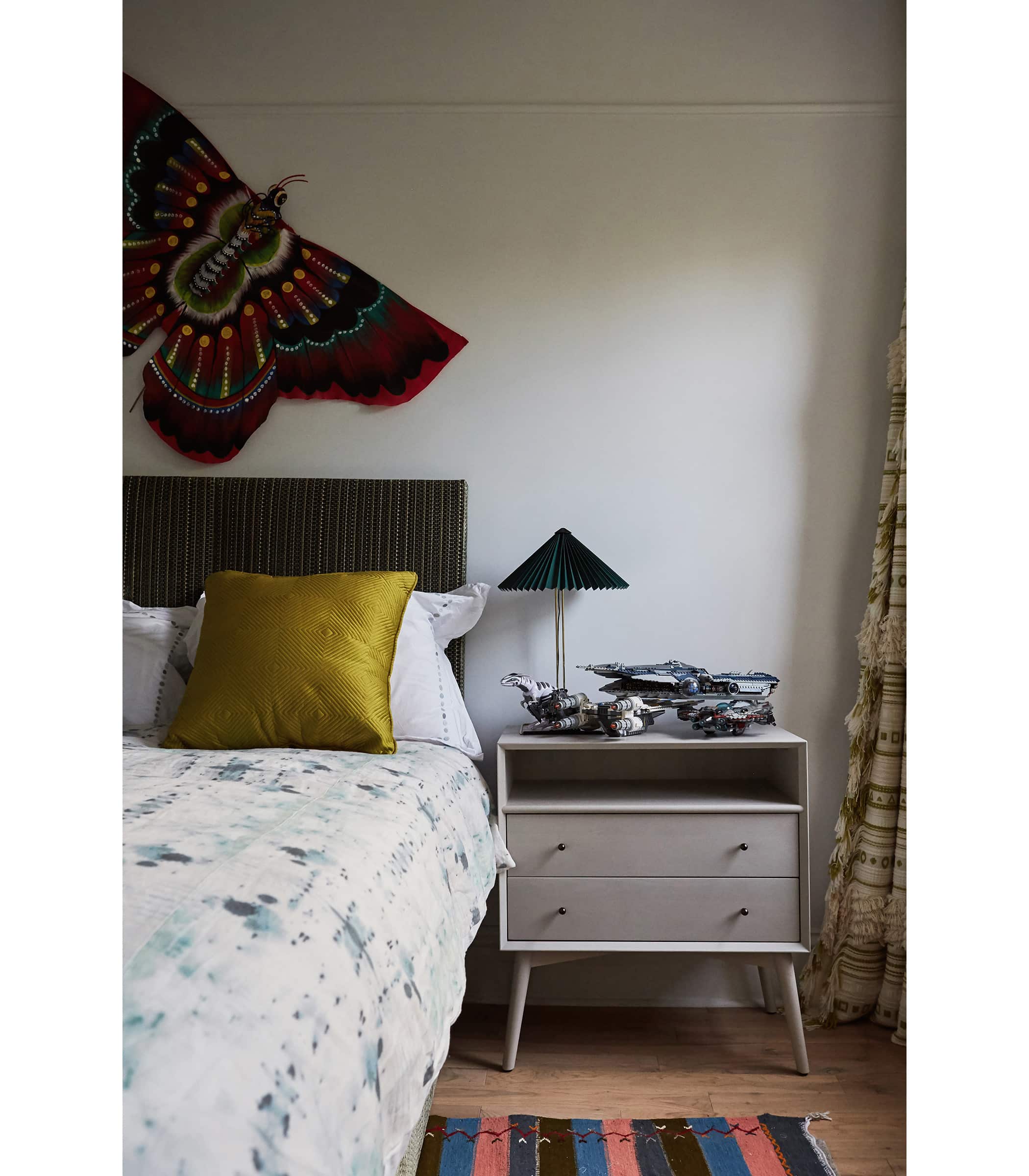 Finds from the family’s travels — here, a Chinese butterfly over the bed — decorate one of the boys’ rooms