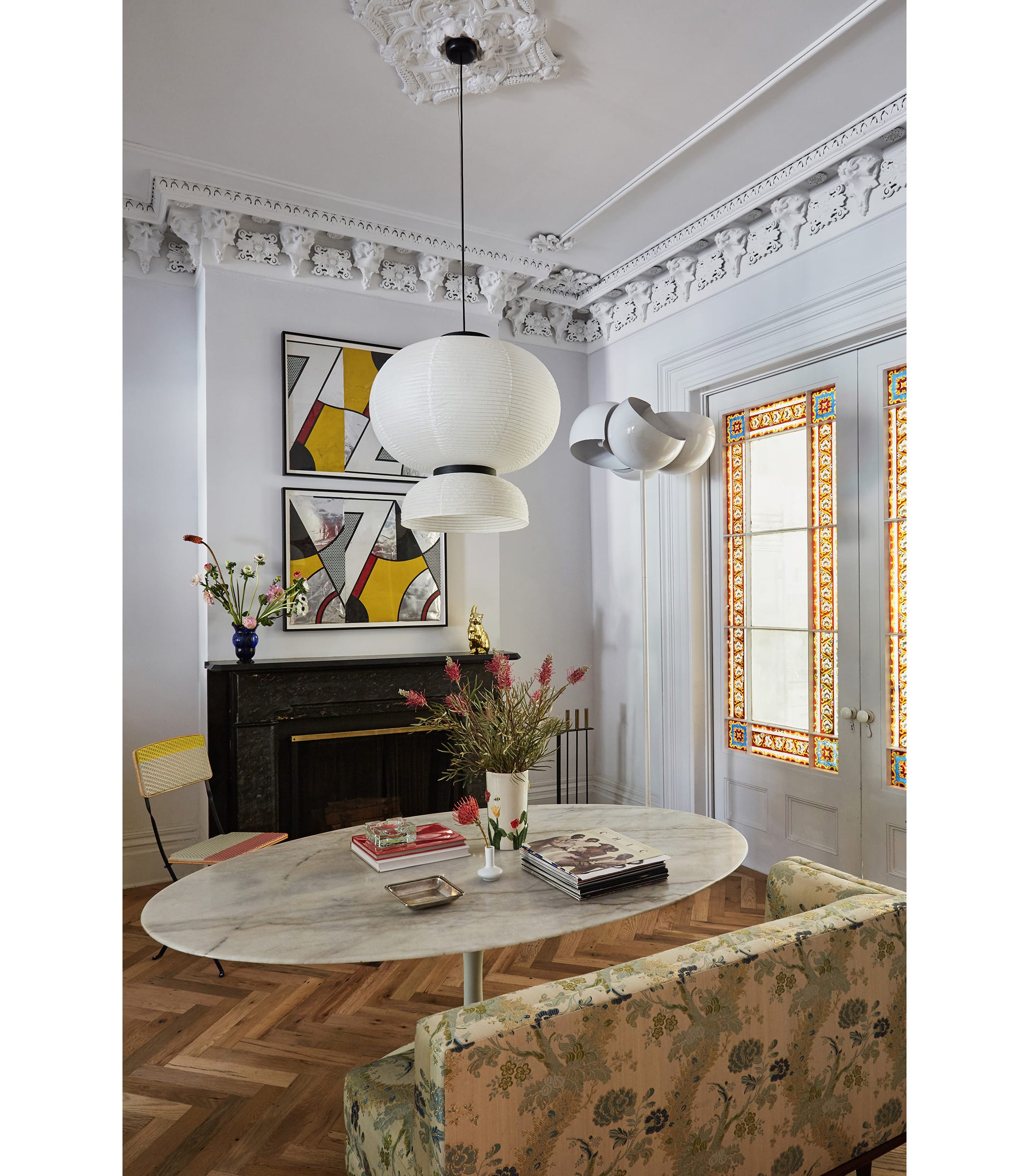 Another Formakami lantern, Roy Lichtenstein prints above the mantel, and a sleek oval tabletop are unabashedly modern against the room’s original pocket doors, found in mint condition, and ornate plasterwork