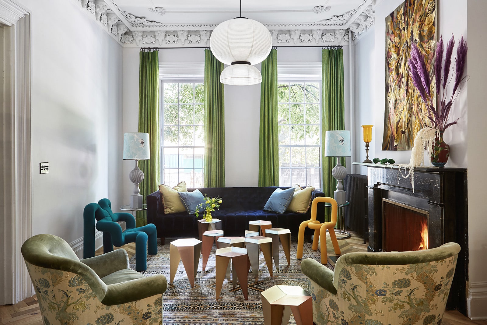 brooklyn interior - Vivid green floor-to-ceiling drapes and out-of-the-ordinary furnishings, including tubular 1980s armchairs by Norwegian designer Terje Ekstrom and modular metal stools that can be grouped as a coffee table, stand out against the pale gray walls of designer Fawn Galli’s Boerum Hill townhouse. A paper lantern from Spanish designer Jaime Hayon’s Formakami series, a contemporary expression of age-old Asian tradition, hangs above