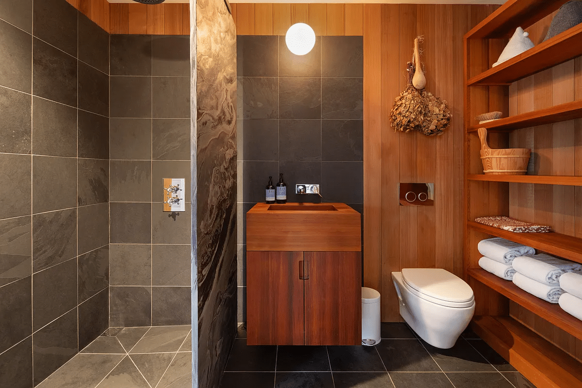 bathroom with walk-in shower, wood shelves and vanity