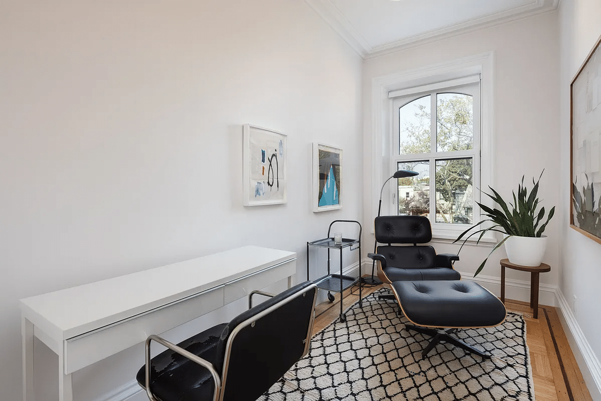 narrow bedroom with wood floor set up as office