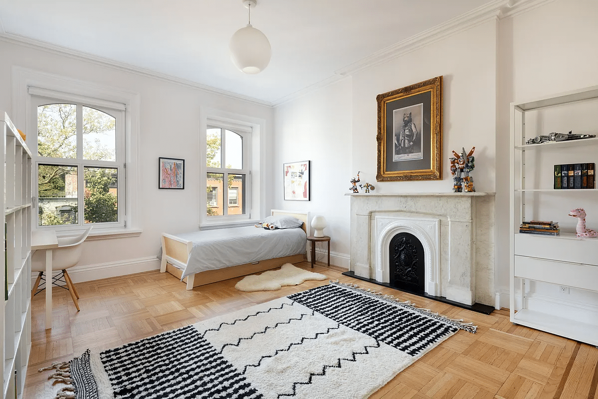 bedroom with wood floor, marble mantel