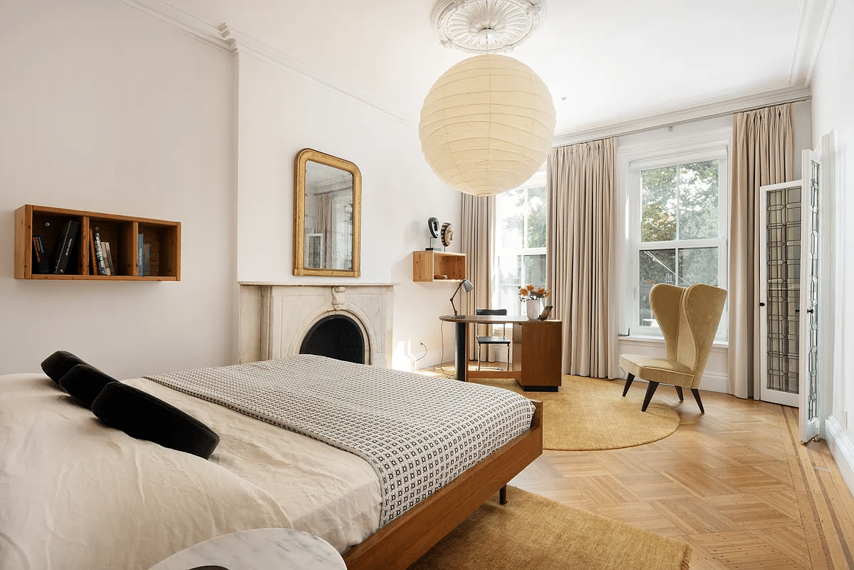 bedroom with high ceiling, wood floor, and a marble mantel