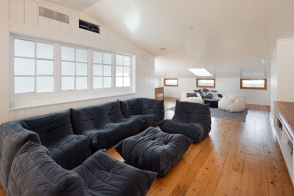 attic family room with angled ceilings, wood floor and skylight