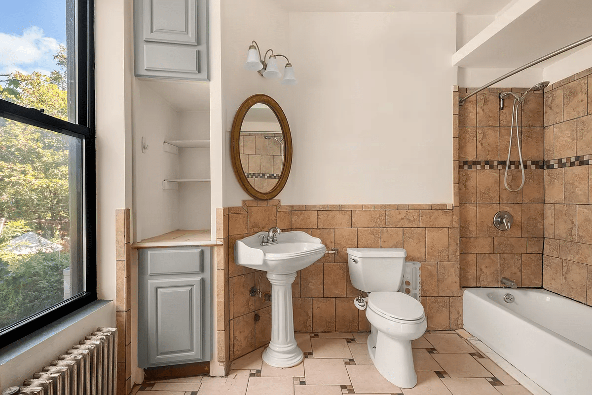 bathroom with white fixtures, brown tile