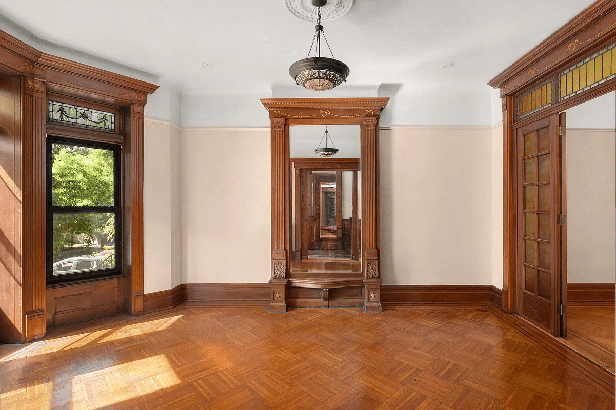 parlor with mirror, stained glass, wood floor