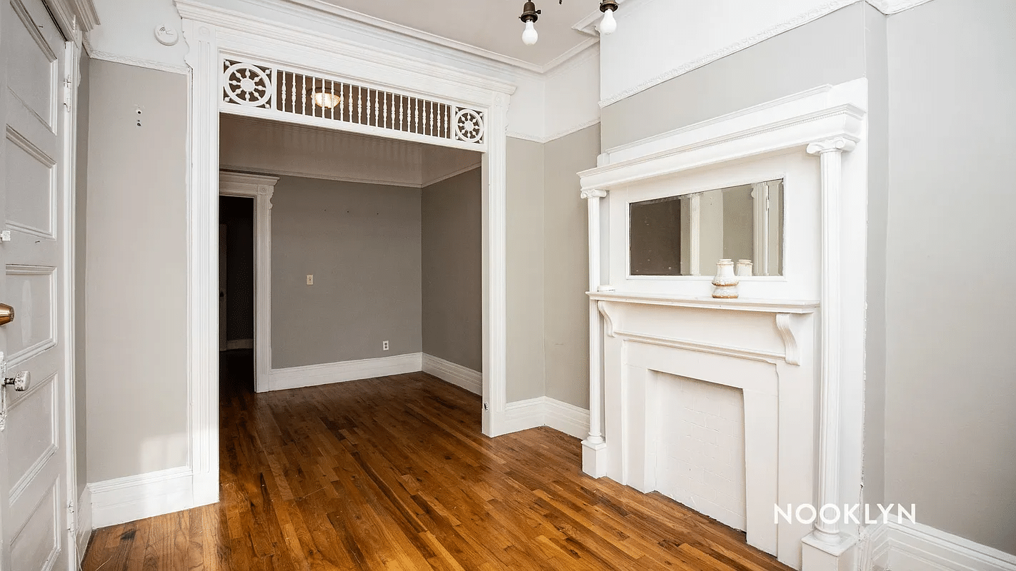 room with mantel, fretwork, chandelier