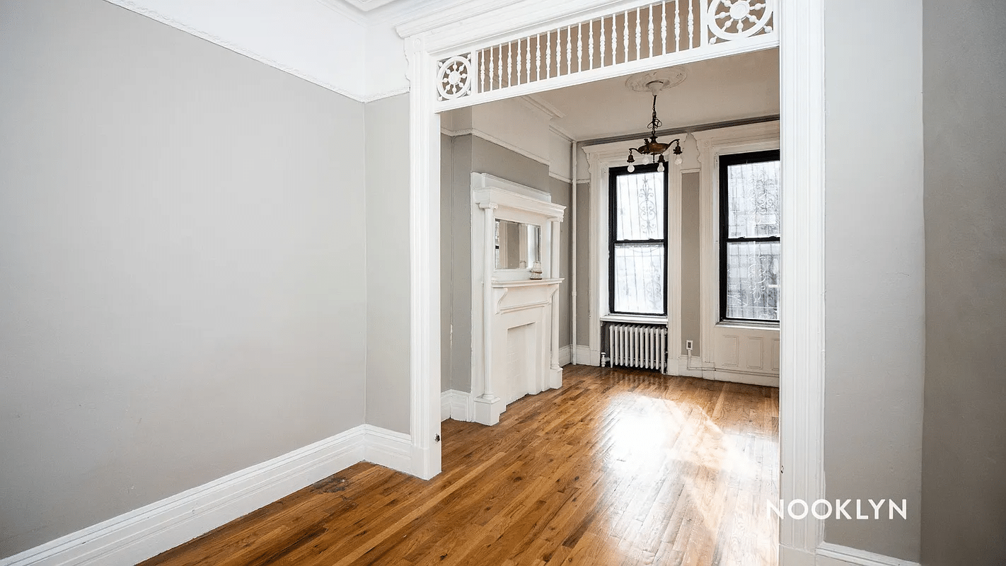 looking into a room with mantel, fretwork, chandelier