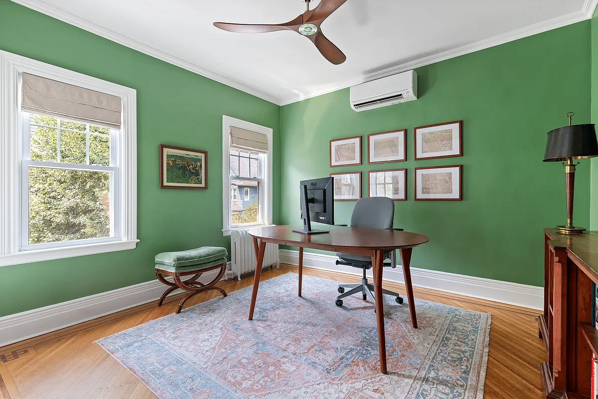 bedroom with green walls set up as an office