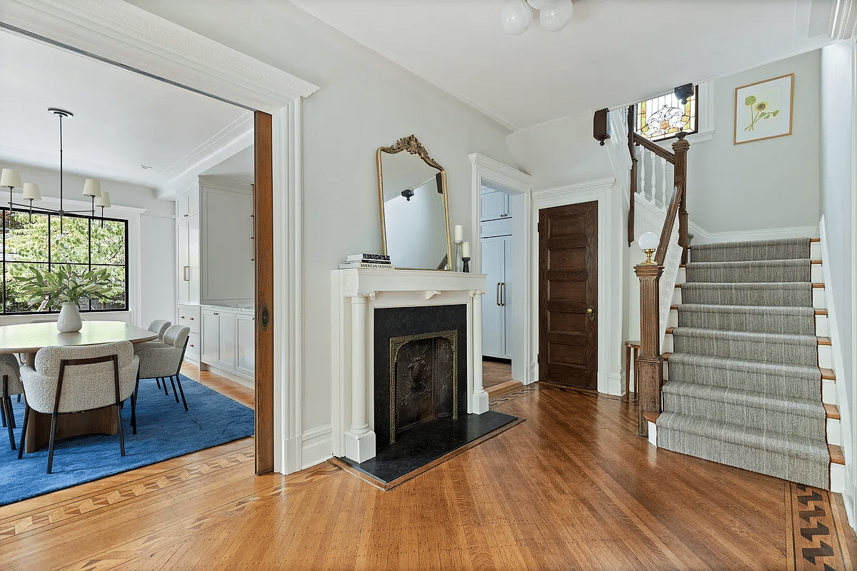 front entry hall with a columned mantel and wood floor