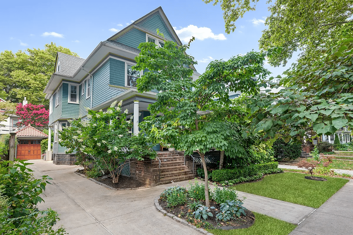 blue shingled detached house with a garage with a tiled roof