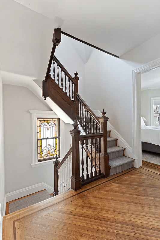 upstairs hall with stained glass window in the stair landing