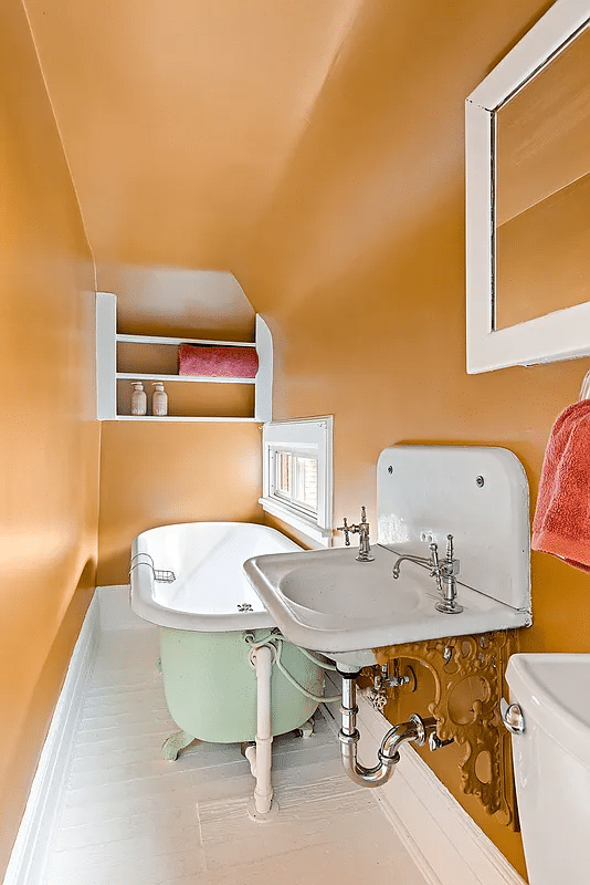 bathroom with wall hung sink, clawfoot tub and wood floors painted white