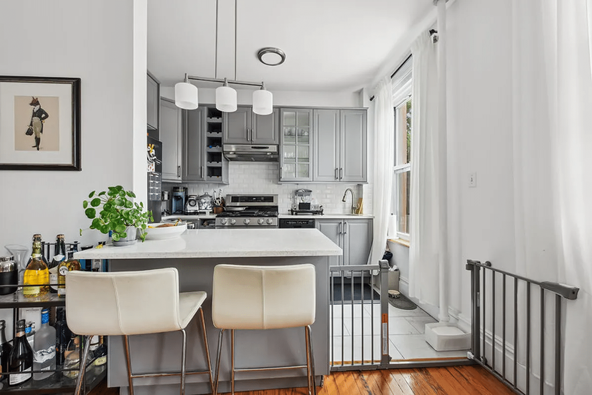 peninsula between living and kitchen with view of gray kitchen cabinets