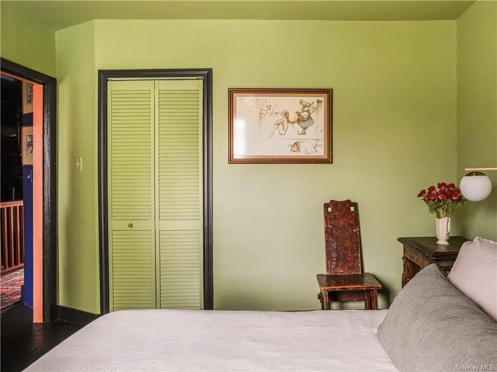 bedroom with green walls and view out to blue hallway