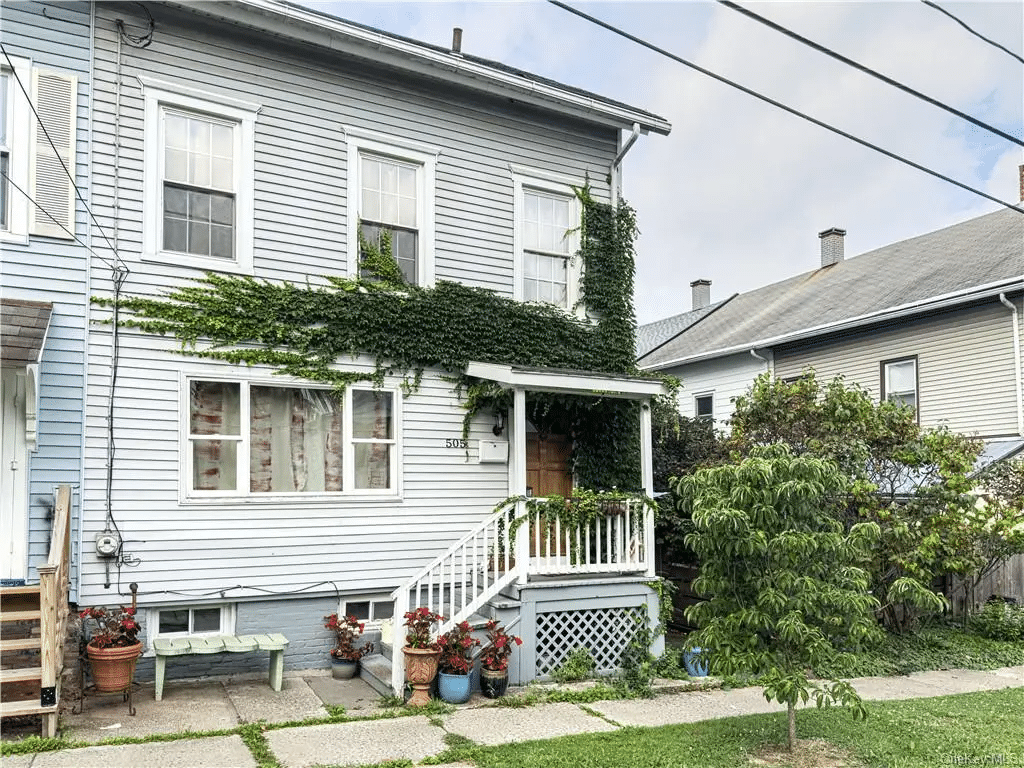 hudson - exterior of the house with a stoop and vines growing across facade