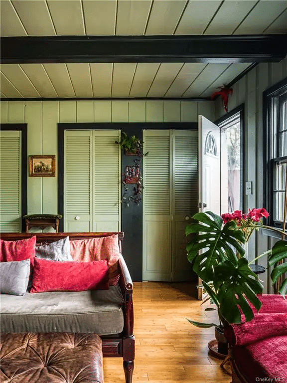 family room with wood floor, beamed ceiling, wall of storage