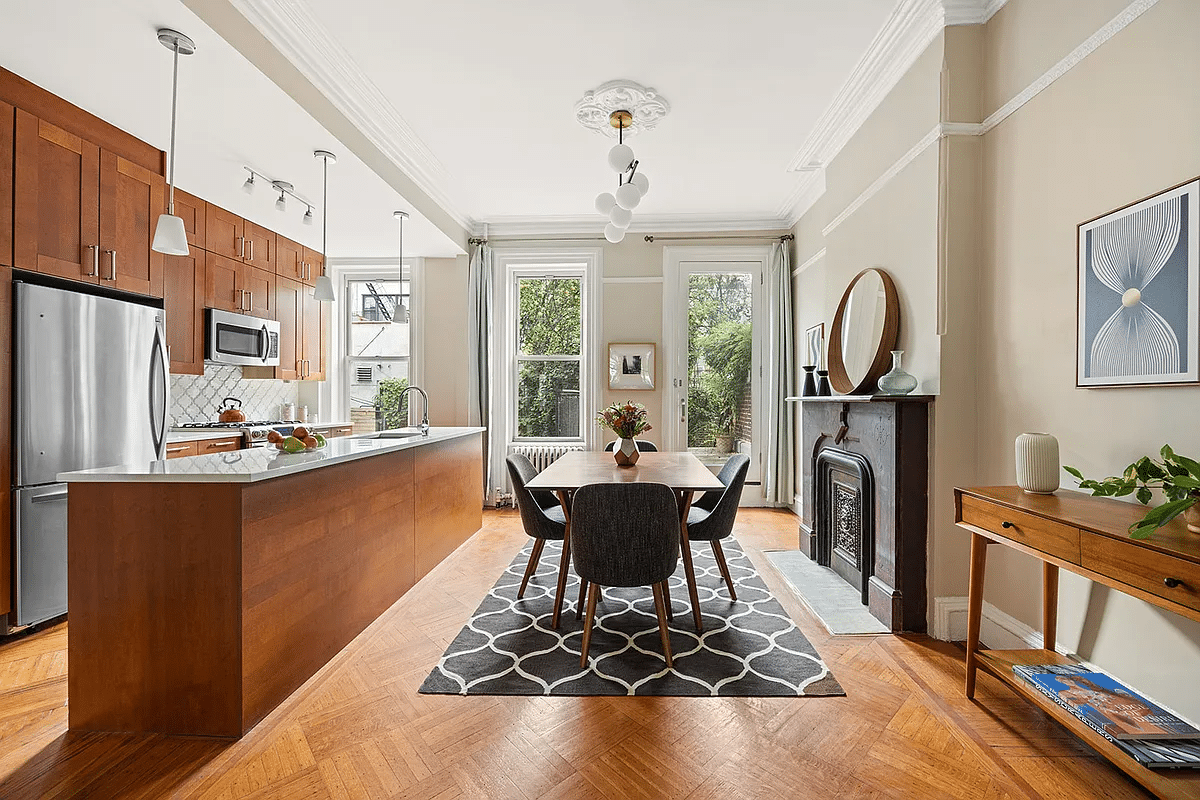 brooklyn open house - dining room and kitchen with a stone mantel and wood cabinets