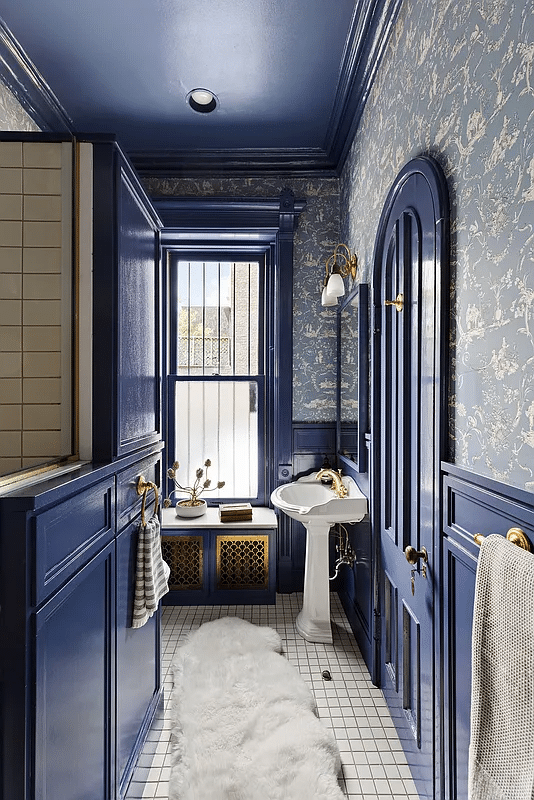 bathroom with blue trim and wallpaper, white fixtures