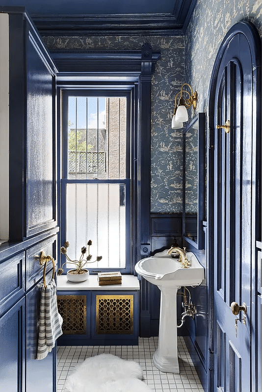 bathroom with blue trim and wallpaper, white fixtures