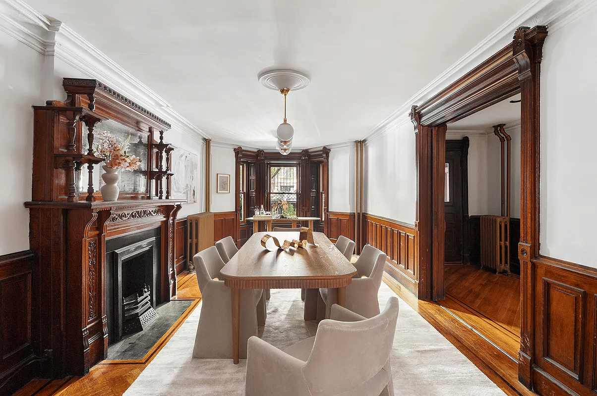 garden level dining room with wainscoting and mantel with mirror and bric-a-brac shelves