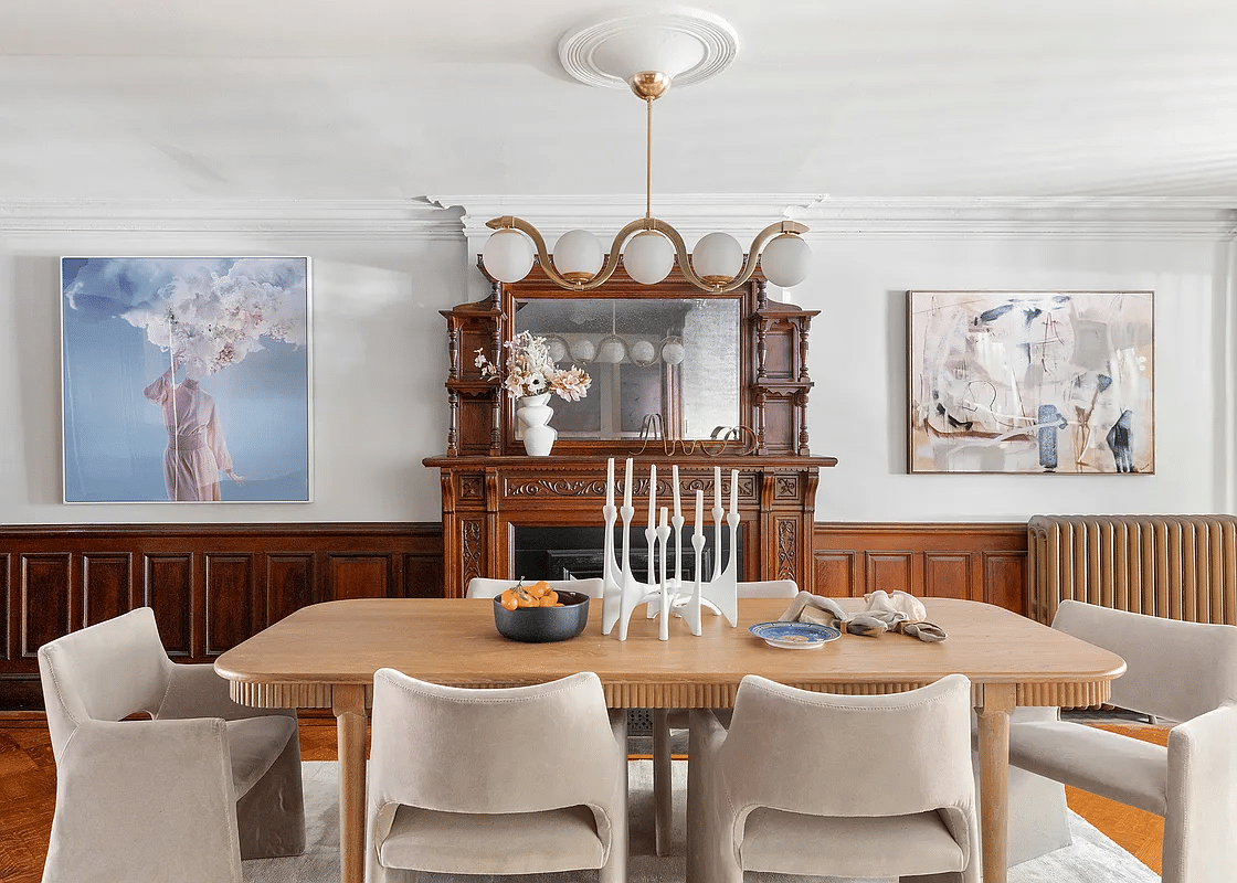 garden level dining room with wainscoting and mantel with mirror and bric-a-brac shelves