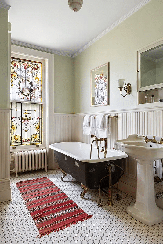 bathroom with claw foot tub, stained glass window