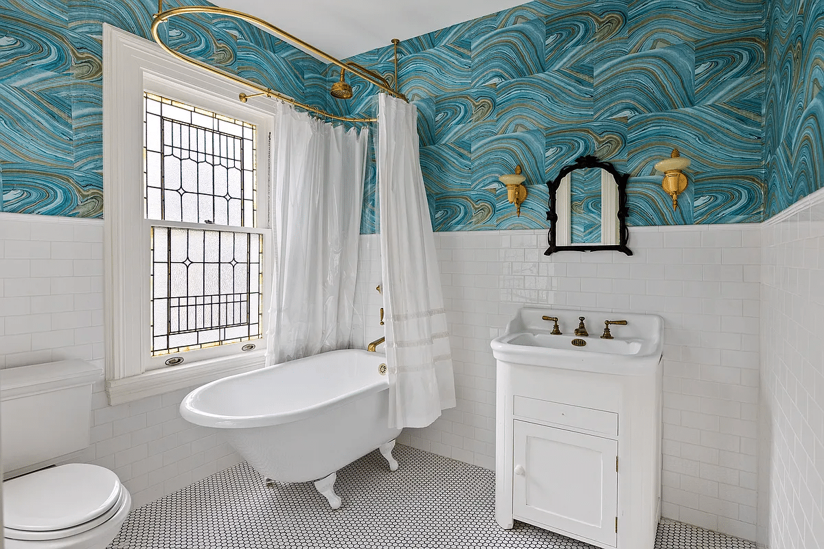 bathroom with claw foot tub, blue marbelized wallpaper