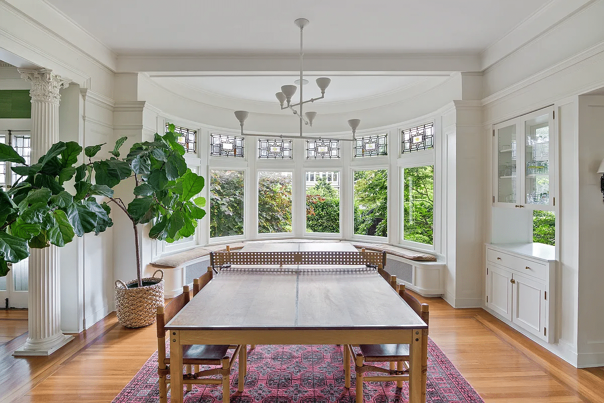 dining room with curved window seat, passthrough to kitchen