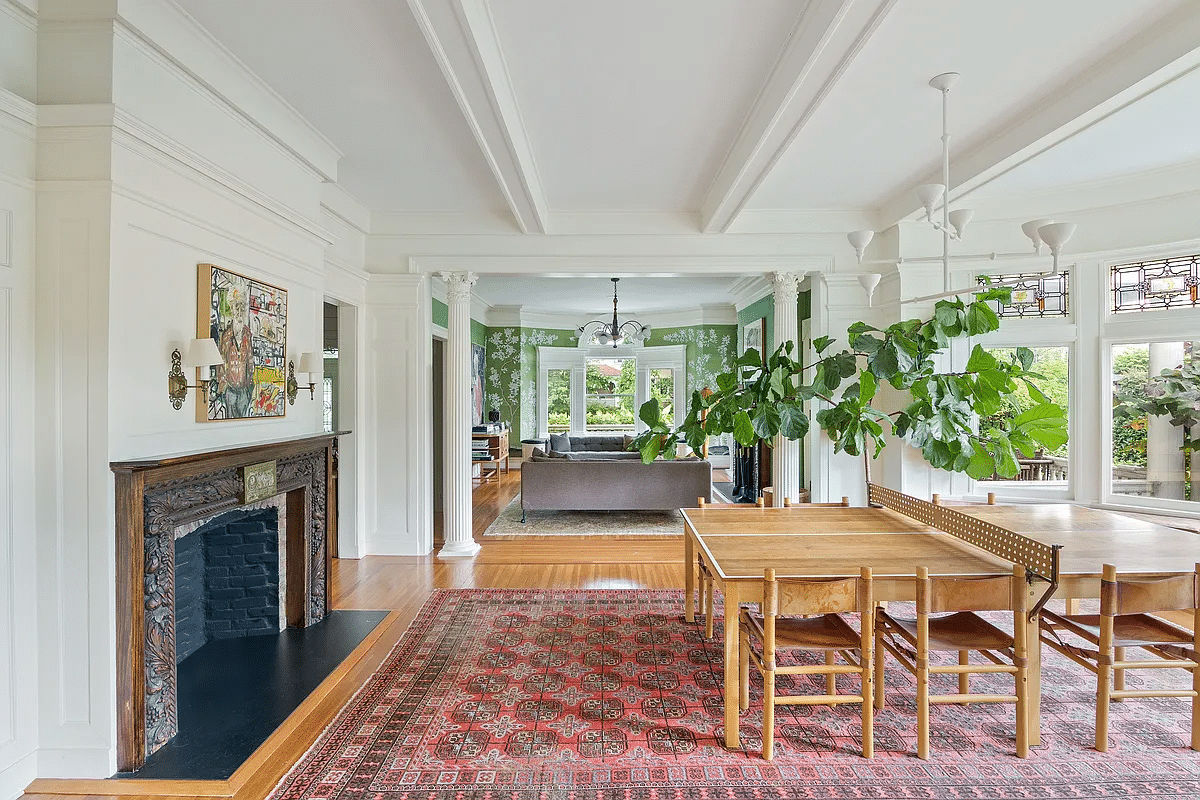 dining room with mantel, columns in doorway leading to parlor