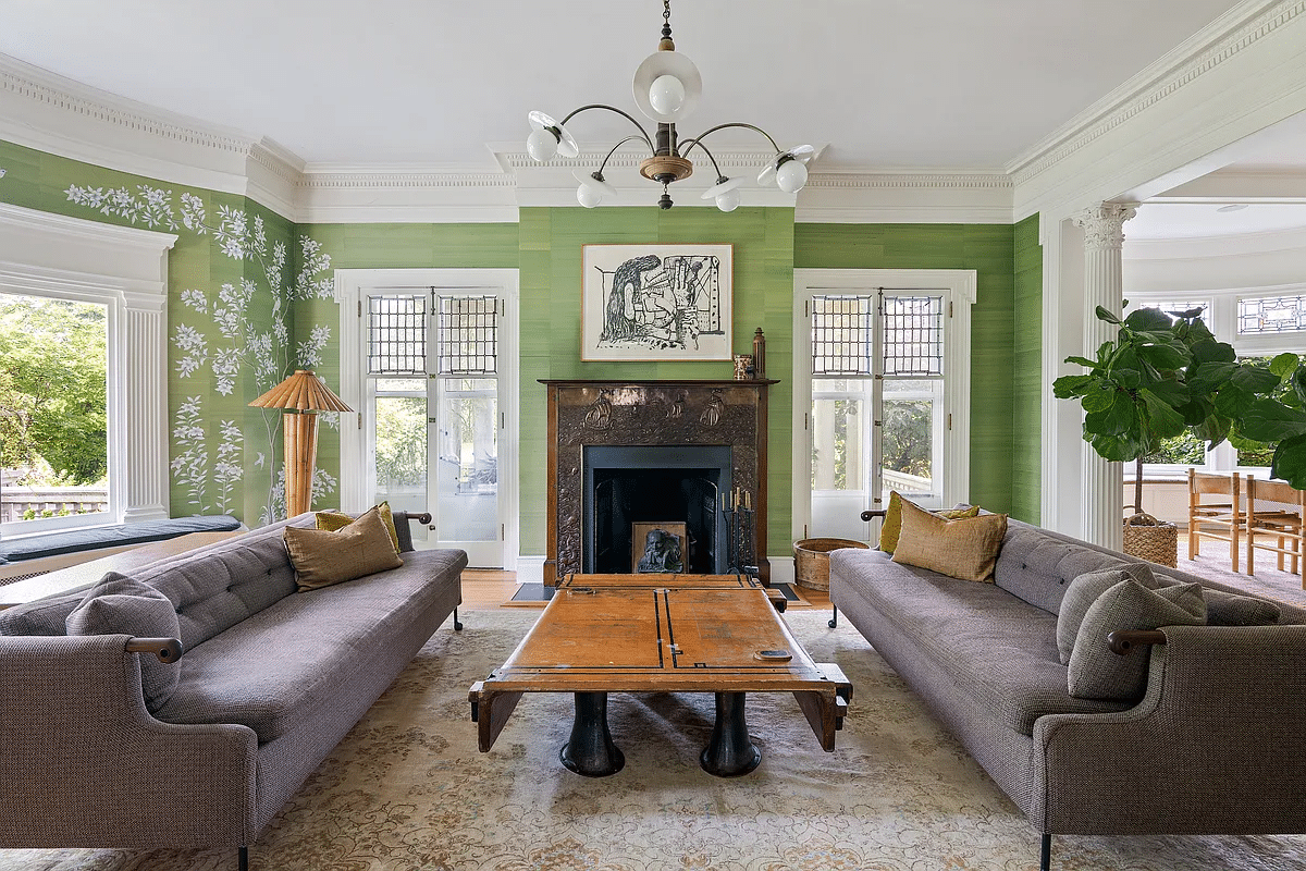 parlor with green wallpaper, a mantel, and french doors to porch