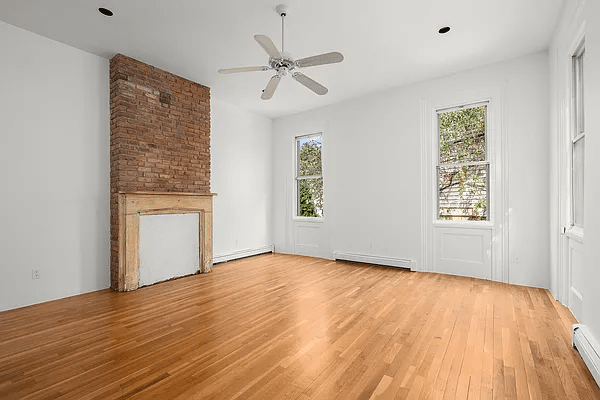 williamsburg - bedroom with wood mantel and a ceiling fan