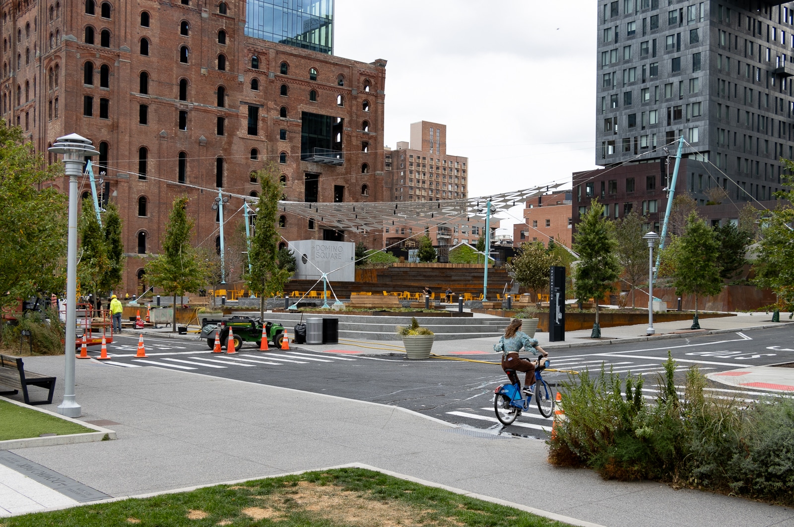 domino square - biker cycles by the new park which has a shade canopy and a domino square sign