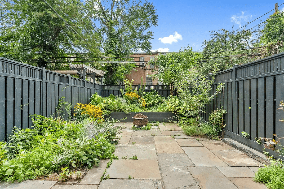 paved rear yard with planting beds