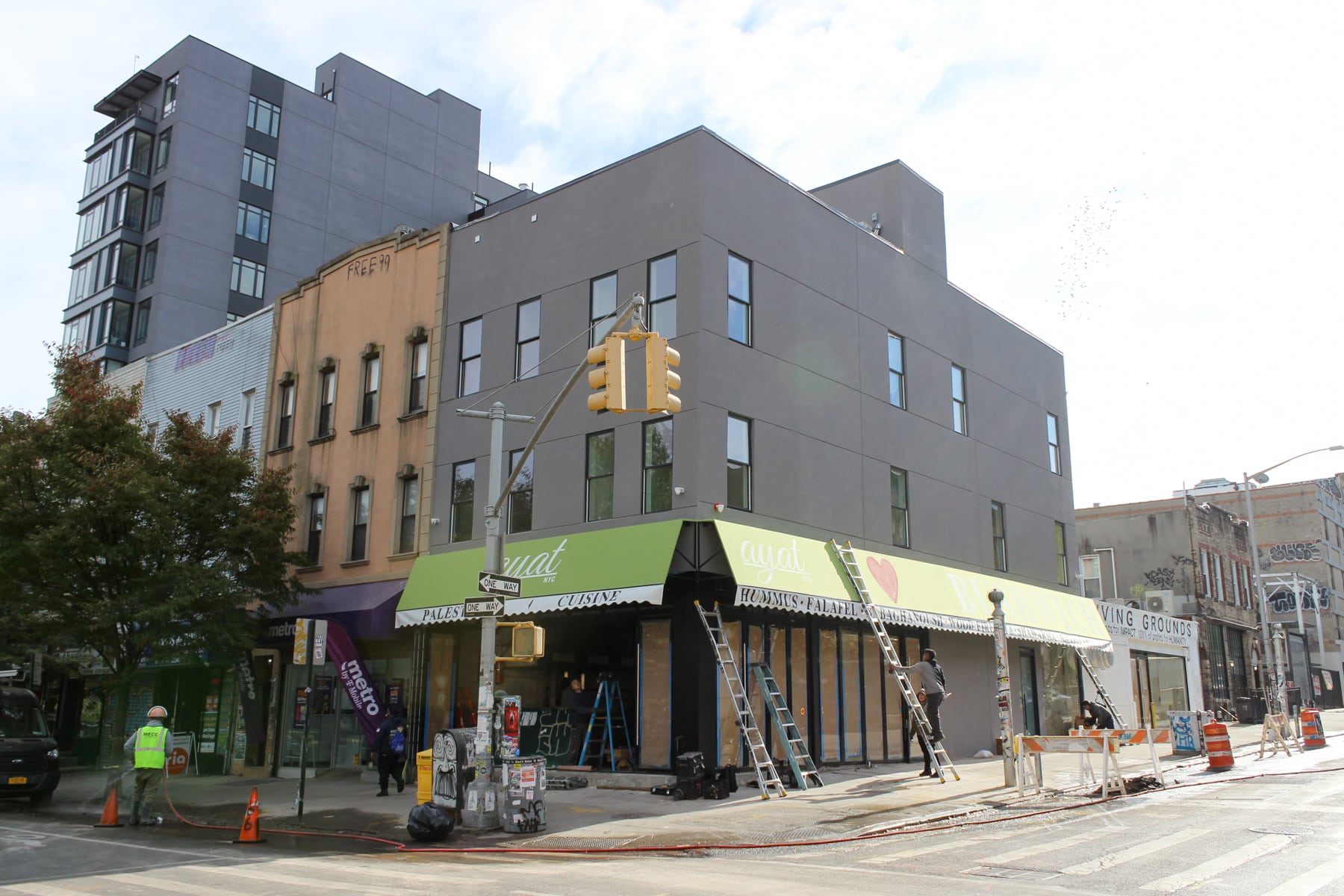 green awnings on the gray stucco corner building