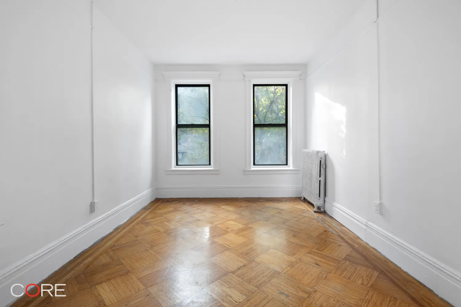 bedroom with two windows and wood floor