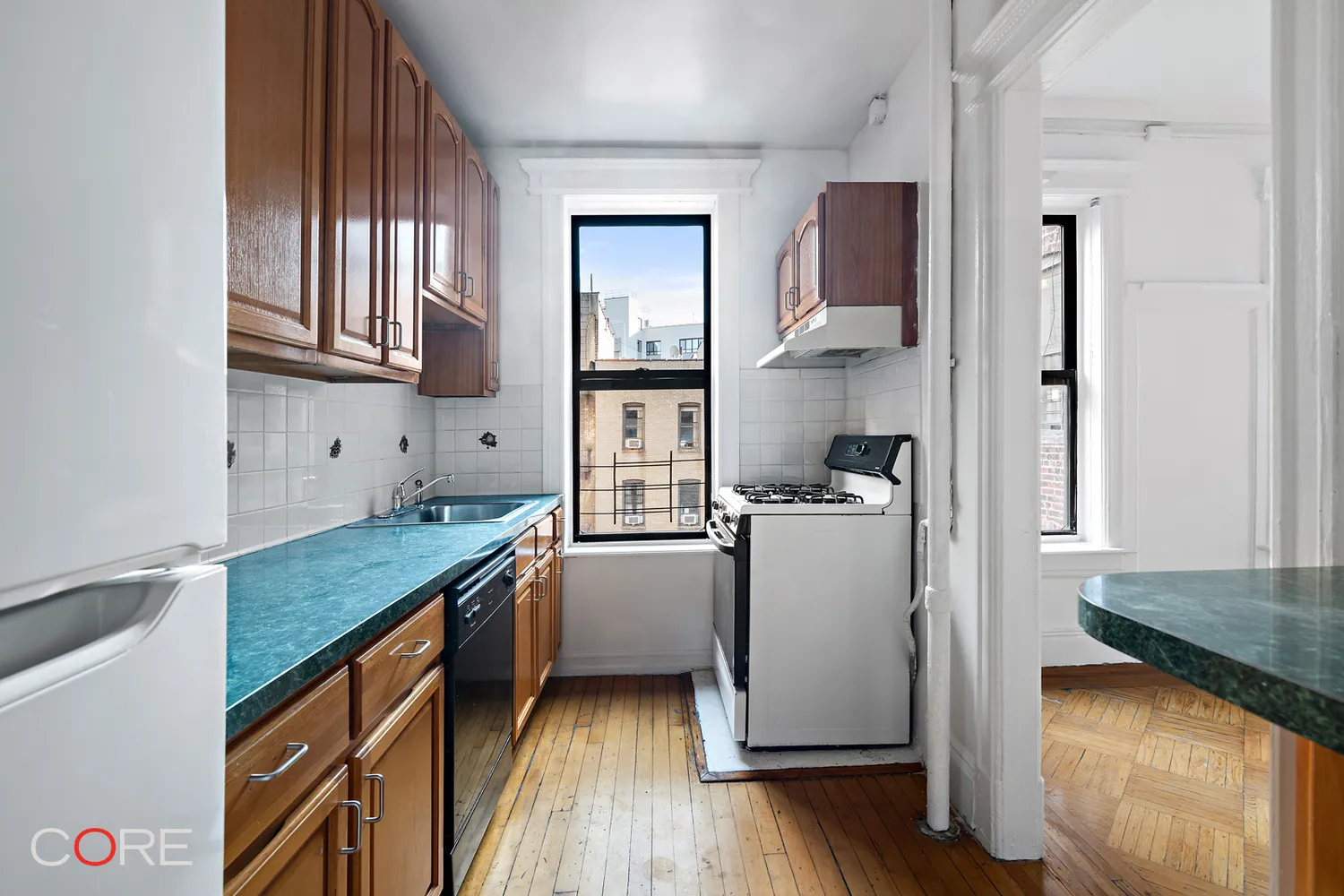 windowed kitchen with wood cabinets and a green counters